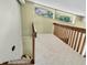 Carpeted hallway with wooden banister and natural light coming through the window at 2287 Demaret Dr, Dunedin, FL 34698