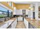 Bright kitchen with granite countertops, white cabinets, stainless steel appliances, and a large window at 2287 Demaret Dr, Dunedin, FL 34698