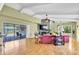 Bright living room with hardwood floors, a stone fireplace, and sliding glass doors leading to the pool at 2287 Demaret Dr, Dunedin, FL 34698