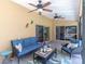 Inviting covered patio with comfortable seating, ceiling fans, and sliding glass doors at 2287 Demaret Dr, Dunedin, FL 34698