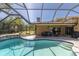 Backyard view of the screened pool, patio area, and well-maintained landscaping creating an outdoor oasis at 2287 Demaret Dr, Dunedin, FL 34698