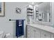 Stylish bathroom with a marble-top vanity, modern fixtures, and decorative shelving enhances the home's appeal at 2412 Hammock Pine Blvd, Clearwater, FL 33761