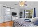 Comfortable bedroom featuring a sliding barn door, modern ceiling fan, and a screened patio with seating at 2412 Hammock Pine Blvd, Clearwater, FL 33761