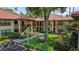 Charming condo building with mature landscaping, tiled roof, and courtyard at 2412 Hammock Pine Blvd, Clearwater, FL 33761