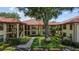 Charming condo building with lush landscaping, sidewalks, and a warm, inviting atmosphere, nestled amidst mature trees at 2412 Hammock Pine Blvd, Clearwater, FL 33761