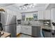 Well-lit kitchen featuring stainless steel appliances, granite countertops, mosaic backsplash, and ample cabinet space at 2412 Hammock Pine Blvd, Clearwater, FL 33761