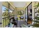 Relaxing screened patio offers a comfortable seating area with views of lush palm trees and a tranquil pond at 2412 Hammock Pine Blvd, Clearwater, FL 33761