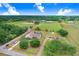 Aerial view showcasing the sprawling property, large home, and scenic surroundings of fields and wooded areas at 2502 Fritzke Rd, Dover, FL 33527