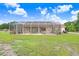 Expansive backyard with screened-in lanai and lush greenery, creating a private oasis at 2502 Fritzke Rd, Dover, FL 33527
