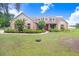 Charming home featuring a well-manicured lawn, complemented by blooming bushes and a inviting front facade at 2502 Fritzke Rd, Dover, FL 33527