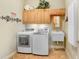 Functional laundry room with washer, dryer, sink, storage cabinets and neutral tile floors at 2502 Fritzke Rd, Dover, FL 33527