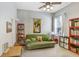 Cozy living room featuring a comfortable green sofa, ceiling fan, and natural light for a relaxing atmosphere at 2502 Fritzke Rd, Dover, FL 33527