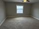 This bedroom has neutral carpet and paint, and a window showing a tranquil lake view at 2557 Cedar Cypress Ct, Tampa, FL 33618