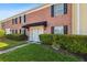 Charming brick townhome with black shutters and a black awning, complemented by vibrant landscaping at 2557 Cedar Cypress Ct, Tampa, FL 33618
