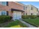 Charming brick townhome with black shutters and a black awning, enhanced by lush landscaping at 2557 Cedar Cypress Ct, Tampa, FL 33618