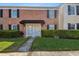 Charming brick townhome with black shutters, a black awning and well-maintained landscaping at 2557 Cedar Cypress Ct, Tampa, FL 33618