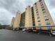 View of condo building featuring parking and desert-style landscaping on an overcast day at 2621 Cove Cay Dr # 206, Clearwater, FL 33760