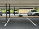 Covered parking featuring multiple cars and numbered spaces at residential building at 2621 Cove Cay Dr # 206, Clearwater, FL 33760