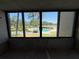 View of community pool and trees, from balcony window, offering a relaxing neighborhood aesthetic at 2621 Cove Cay Dr # 206, Clearwater, FL 33760