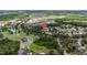 This aerial view shows the house located near a body of water, golf course, and apartment complex in the neighborhood at 26749 Middleground Loop, Wesley Chapel, FL 33544