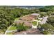 This aerial view captures a home with a green lawn, fenced yard, and proximity to tree coverage at 26749 Middleground Loop, Wesley Chapel, FL 33544