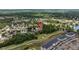 An aerial view shows a neighborhood home near a golf course and a multi-story apartment complex at 26749 Middleground Loop, Wesley Chapel, FL 33544