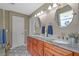 This bathroom features dual sinks, granite countertops, and stylish fixtures with a decorative tile floor at 26749 Middleground Loop, Wesley Chapel, FL 33544