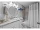 Bright bathroom with marble countertop, decorative mirror, and shower at 26749 Middleground Loop, Wesley Chapel, FL 33544