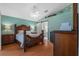 Spacious bedroom with wood floors, a ceiling fan and decorative wood furniture at 26749 Middleground Loop, Wesley Chapel, FL 33544