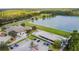Aerial view of a clubhouse with a lakeside restaurant, landscaping, and parking provides a great community gathering spot at 26749 Middleground Loop, Wesley Chapel, FL 33544