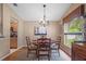 Cozy dining area with a round table, chandelier, and a view of the backyard through a window at 26749 Middleground Loop, Wesley Chapel, FL 33544