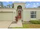 Welcoming entrance featuring a red door and manicured landscaping at 26749 Middleground Loop, Wesley Chapel, FL 33544