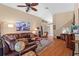 Inviting living room with hardwood floors, a large sectional sofa, and a view into other rooms at 26749 Middleground Loop, Wesley Chapel, FL 33544