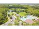 Aerial view of the community pool, tennis and basketball court, and parking, nestled in a green landscape at 26749 Middleground Loop, Wesley Chapel, FL 33544