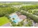 Aerial view of community pool, playground and outdoor space with lush surroundings and ample parking at 26749 Middleground Loop, Wesley Chapel, FL 33544