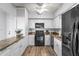 Well-maintained kitchen features granite countertops, white cabinets, and modern black appliances at 30 Turner St # 704, Clearwater, FL 33756