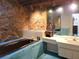 Unique bathroom with stone walls, large tub, and vanity at 3200 Sandy Ridge Dr, Clearwater, FL 33761