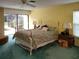 Bright bedroom boasts a queen bed, sliding glass doors to the outside, and ample natural light at 3200 Sandy Ridge Dr, Clearwater, FL 33761