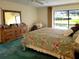 Bedroom featuring view of the pool, dresser, queen bed, and neutral walls at 3200 Sandy Ridge Dr, Clearwater, FL 33761
