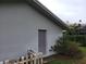 Exterior shot of the home with a grey door, trim, and fenced in yard and mature landscaping at 3200 Sandy Ridge Dr, Clearwater, FL 33761