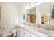 Bright bathroom featuring double sinks, neutral-toned tile, and coastal decorations at 37338 Sandra Ave, Zephyrhills, FL 33542