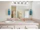 Bathroom featuring double sinks, a large mirror, and neutral toned tile at 37338 Sandra Ave, Zephyrhills, FL 33542