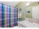 Cozy bathroom featuring a tub with a colorful plaid shower curtain and vanity sink at 37338 Sandra Ave, Zephyrhills, FL 33542