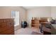 Bedroom with a window and an organized workspace including dark-wood dresser and open shelving at 37338 Sandra Ave, Zephyrhills, FL 33542