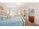 Inviting bedroom with blue bedding, light-toned furniture, and a view into the adjacent room at 37338 Sandra Ave, Zephyrhills, FL 33542