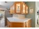 Updated kitchen with white countertops, wood cabinets, and decorative glass-front display cabinets, perfect for entertaining guests at 37338 Sandra Ave, Zephyrhills, FL 33542