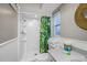 Well-lit bathroom featuring a shower, tropical-themed shower curtain, and decorative mirror at 3749 Mckay Creek Dr, Largo, FL 33770