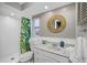 Bathroom featuring a shower, sink and toilet with a tropical-themed shower curtain and round mirror at 3749 Mckay Creek Dr, Largo, FL 33770