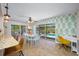 Bright dining area featuring tropical wallpaper, sliding doors to the pool, and modern furnishings at 3749 Mckay Creek Dr, Largo, FL 33770