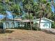 Single-story home with an attached two-car garage featuring a light blue exterior and manicured landscaping at 3749 Mckay Creek Dr, Largo, FL 33770
